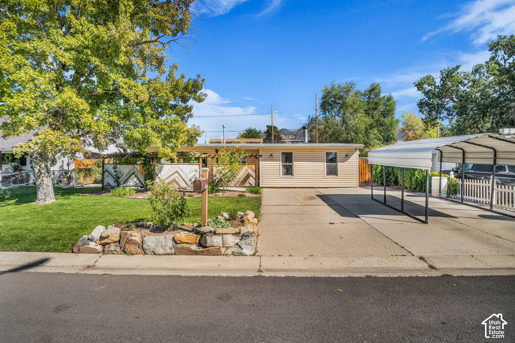 Single-story residence featuring horizontal siding, a covered carport, and a paved driveway