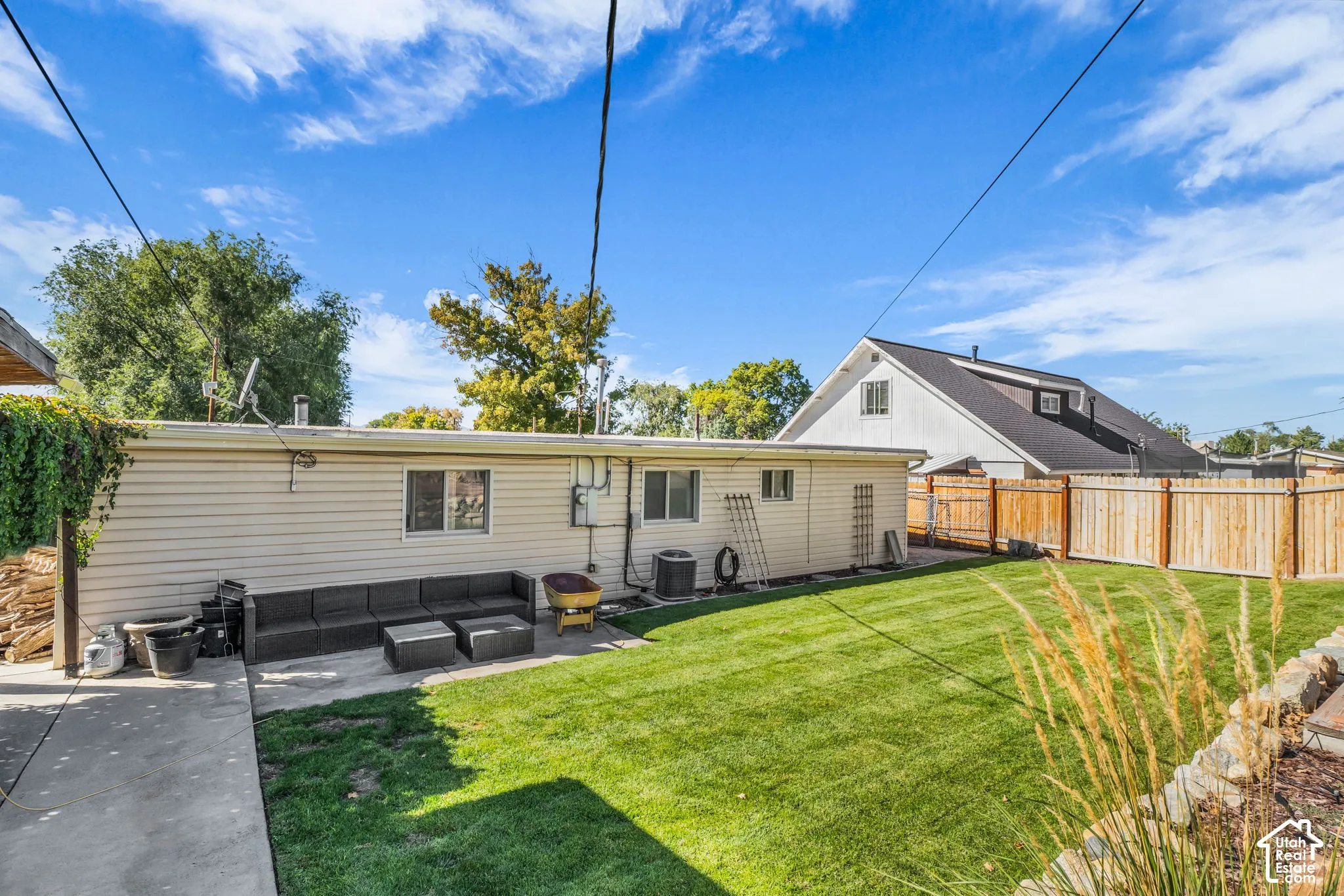 Expansive backyard featuring a manicured lawn, concrete patio, and privacy fencing