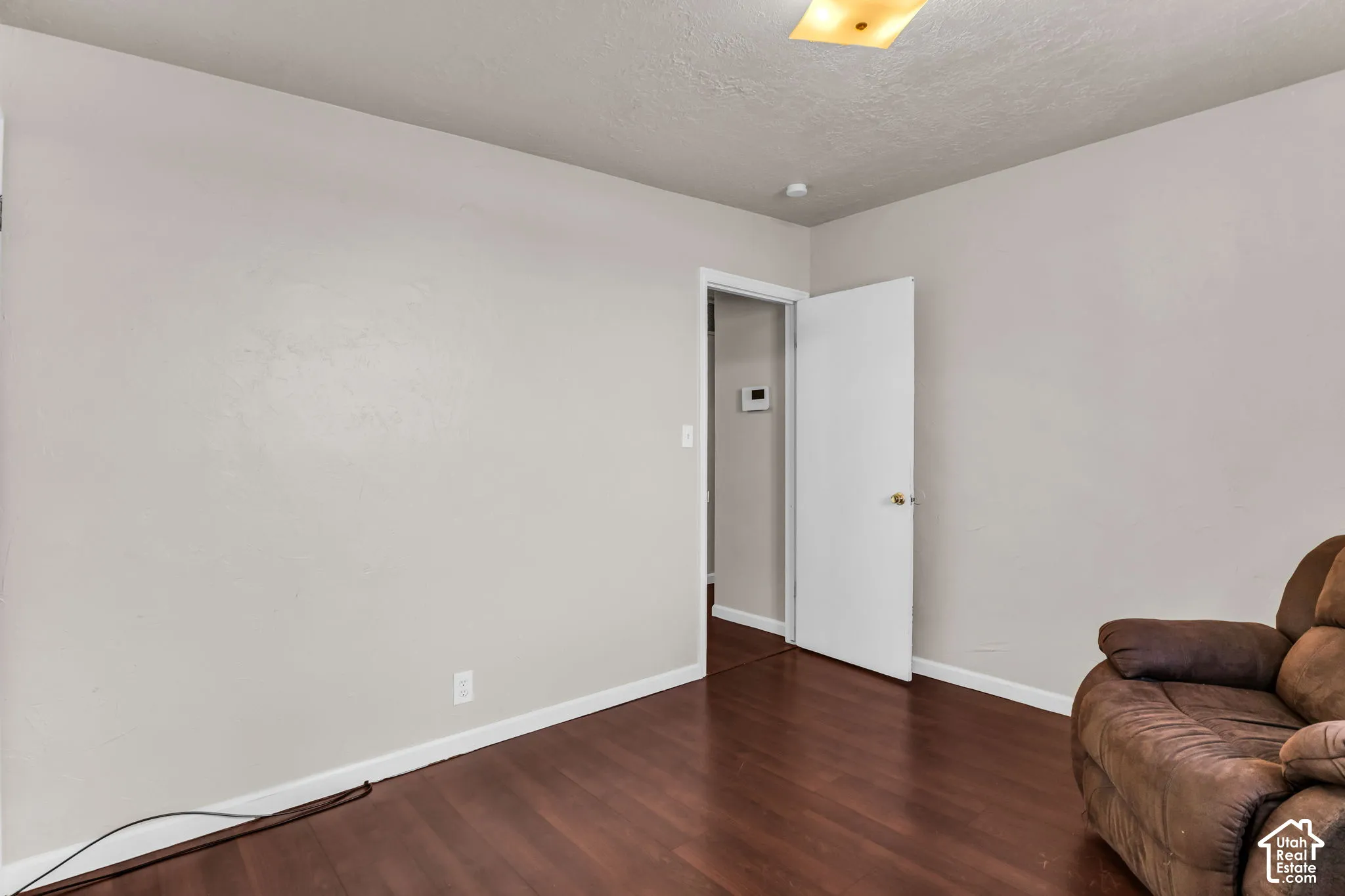 Wood-finish flooring with white baseboards and light-toned walls