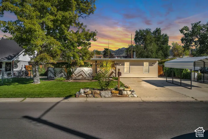 Single-story residence featuring horizontal siding, a driveway, and a detached carport
