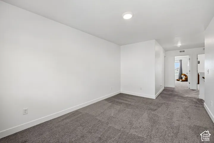 Plush gray carpet flooring, white painted walls, and recessed ceiling lighting