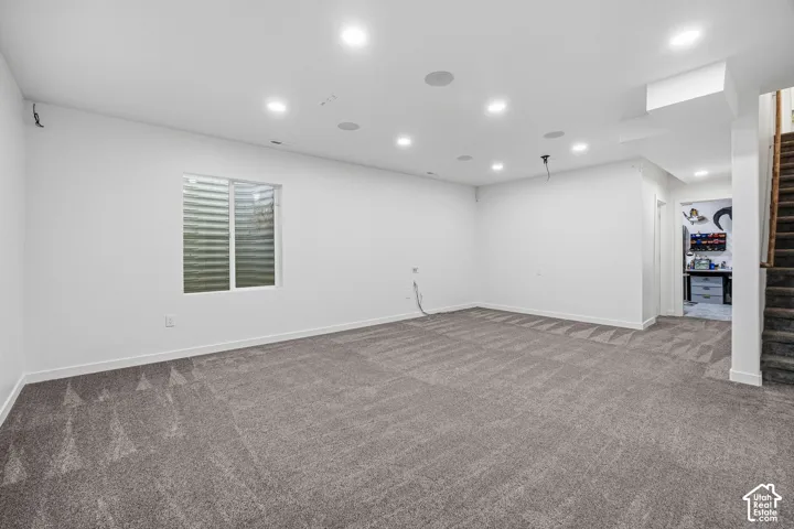 Recessed lighting, light gray carpet, and a large egress window
