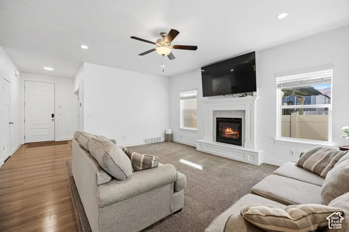 Carpeted living area with a built-in fireplace, crown molding, and recessed lighting