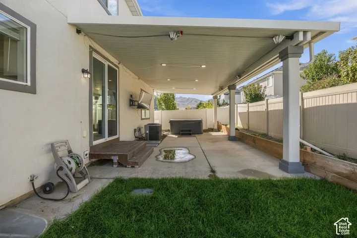 Covered patio with recessed lighting, concrete flooring, sliding glass door access, and a built-in planter box