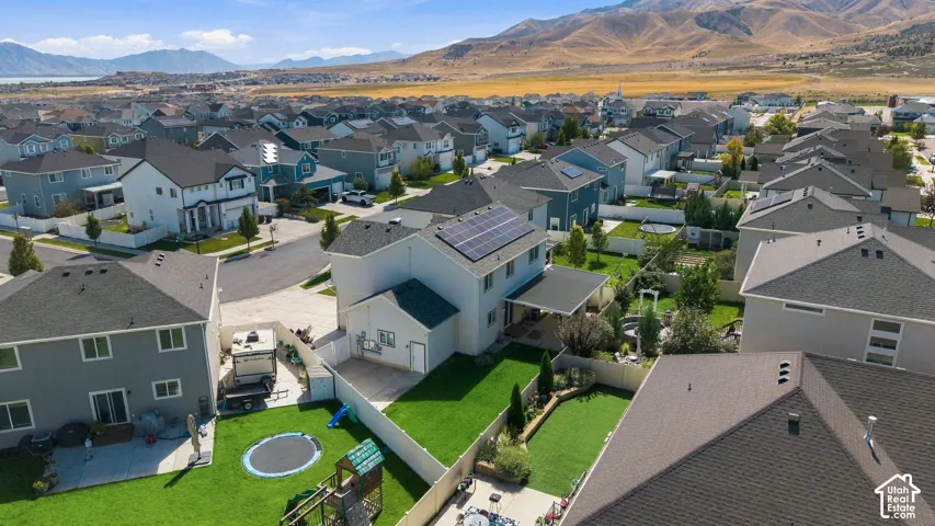 Residential community with varied housing styles, solar panels, and mountain scenery