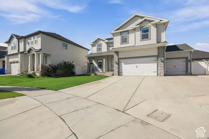 Two-story residence featuring light-colored siding, a covered entry, and an attached two-car garage