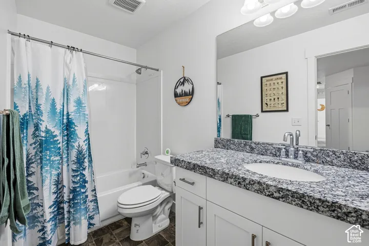 White vanity with cabinet storage, solid surface countertop, and integrated sink
