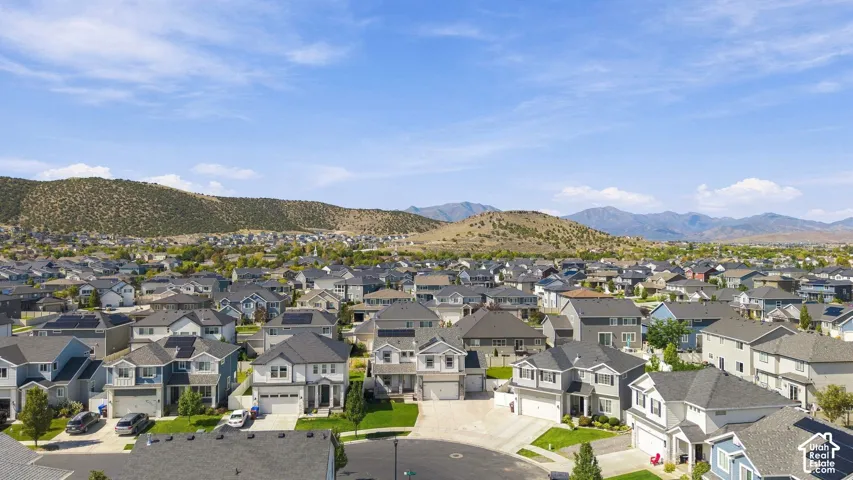 Residential community with varied architectural styles situated against a backdrop of rolling hills and distant mountains