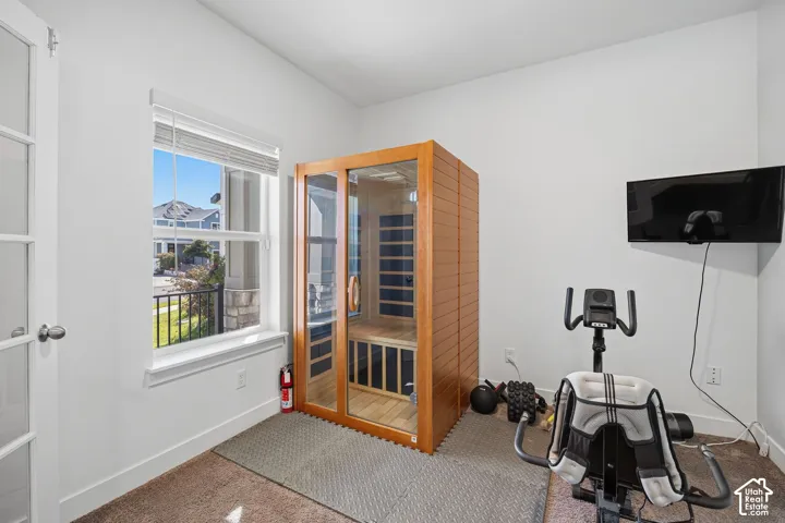 Built-in wooden sauna with glass paneling, double-paned window, and carpet flooring