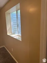 Window recess with neutral painted walls and carpeted flooring
