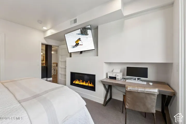 Integrated media wall with a built-in linear fireplace, recessed lighting, and a dedicated desk alcove featuring a wood-finish desktop