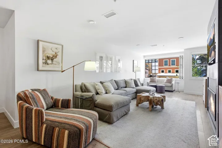Recessed lighting, wood-finish flooring, a built-in fireplace, and large windows with integrated blinds