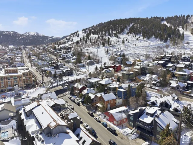 Snow-dusted mountain terrain with residential buildings and a bridge structure