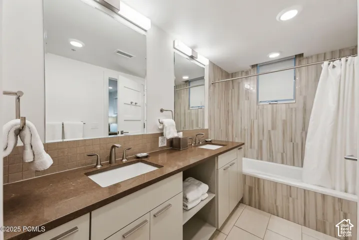 Dual vanity with integrated sinks, expansive mirror, and contemporary lighting