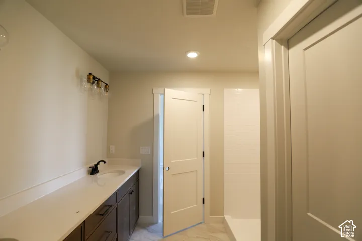 Dual sink vanity with dark wood-finish cabinetry, light countertop, and matte black fixtures