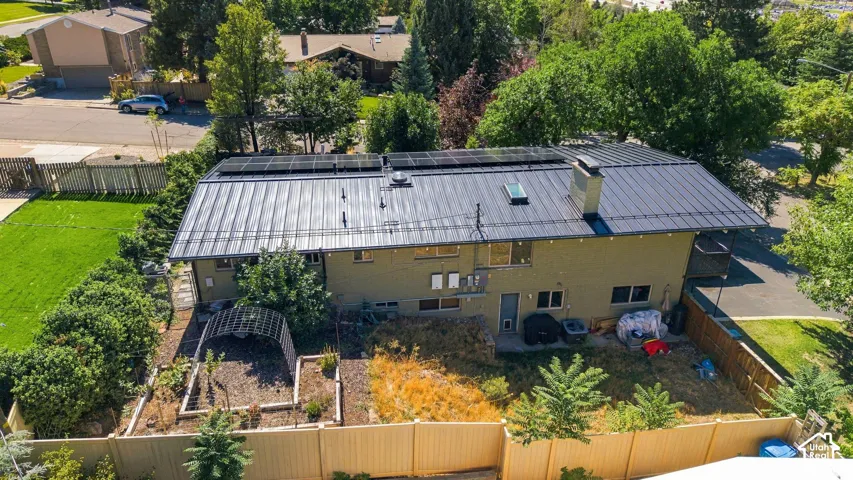 Metal roof, solar panels, skylight, and fenced yard