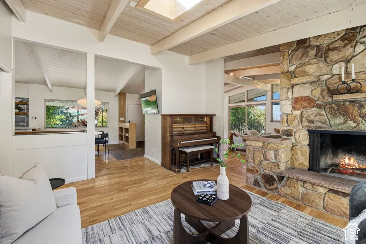 Vaulted wood-paneled ceilings with exposed beams, skylight, and stone-clad fireplace