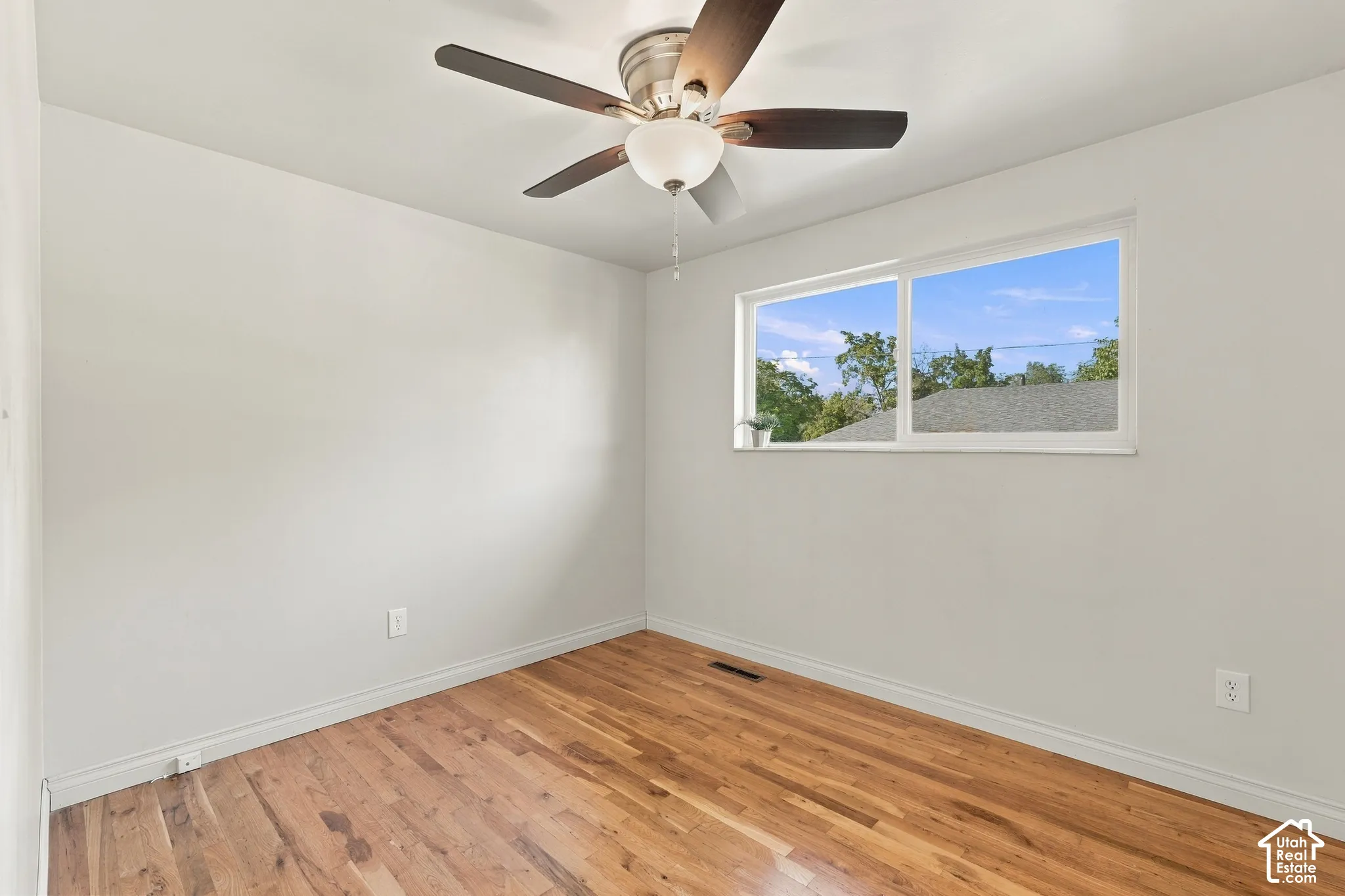 Hardwood flooring, recessed window, ceiling fan with integrated lighting, and white wall finishes