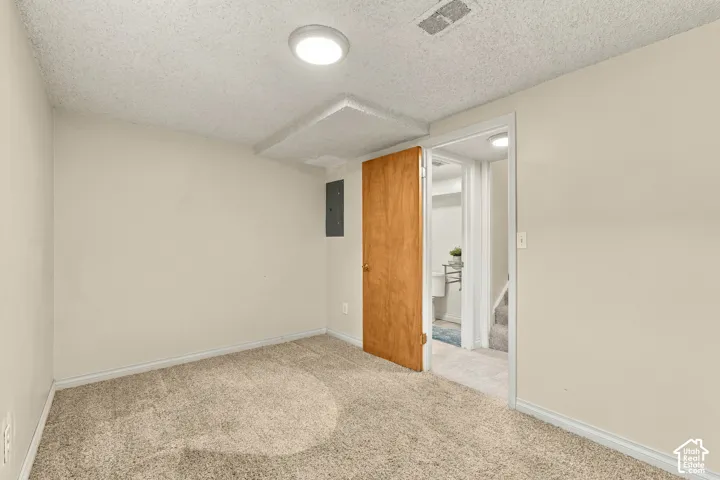 Recessed lighting, wood-panel door, and textured ceiling