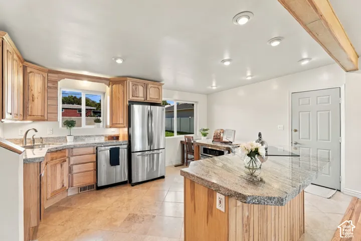 Kitchen featuring wood-finish cabinetry, stainless steel appliances, granite countertops, tile flooring, and recessed lighting
