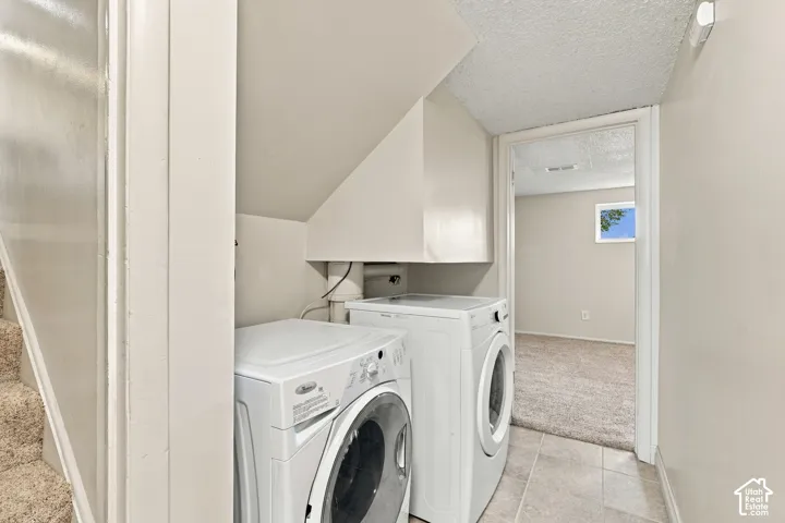 Laundry area with tile flooring and a front-loading washer