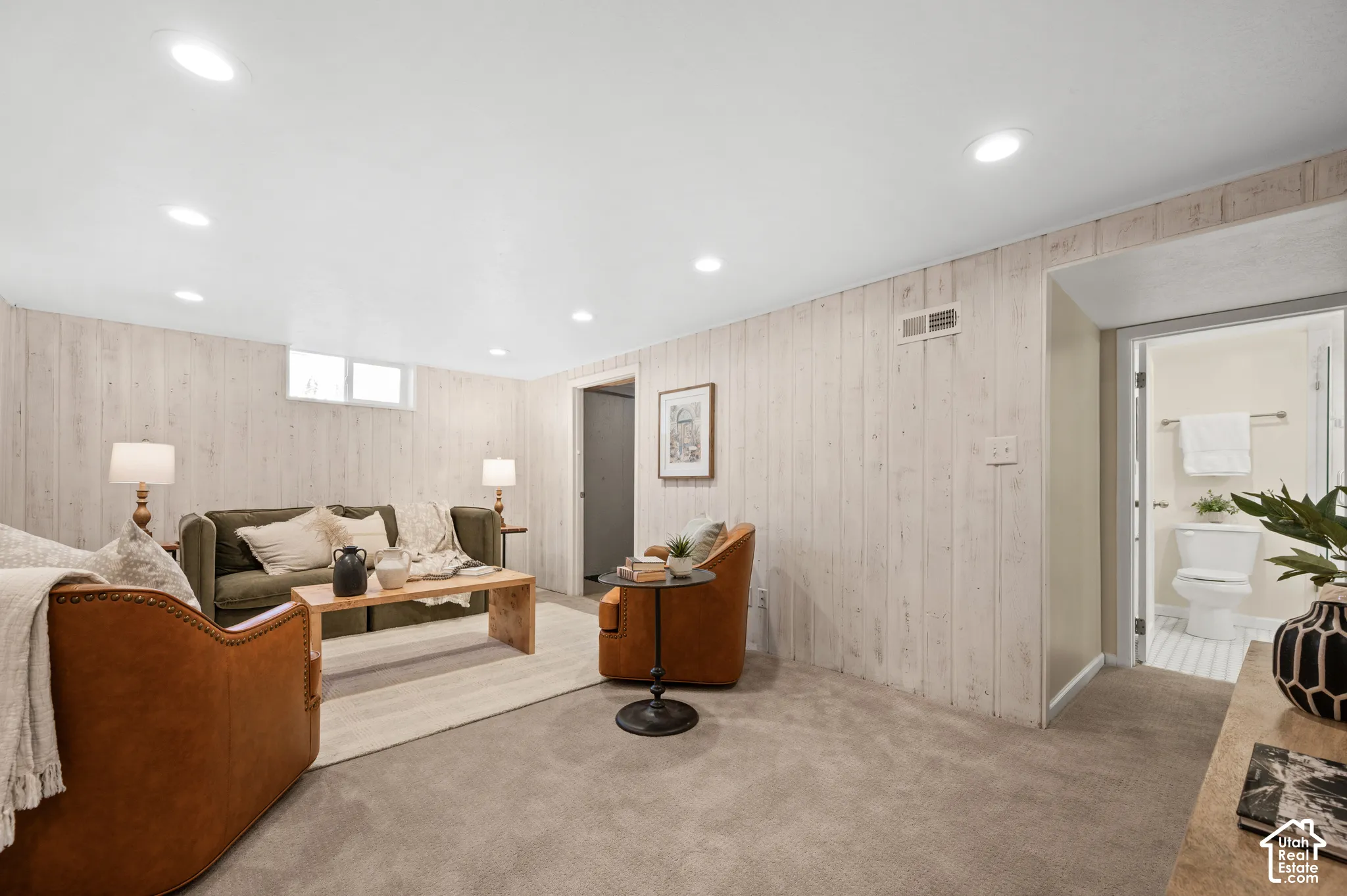 Interior space featuring white-washed wood wall paneling, recessed lighting, and neutral carpeting