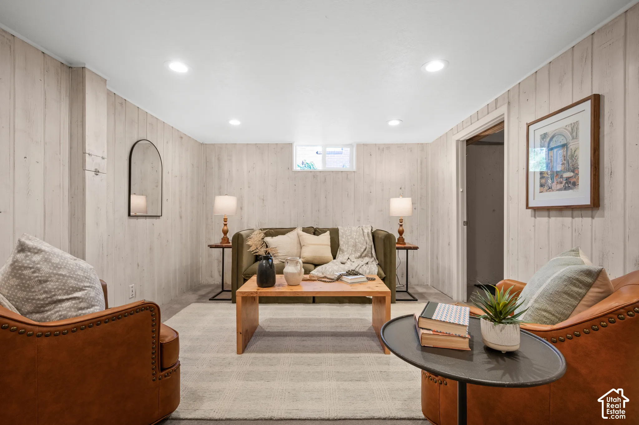 Vertical light-toned wood-finish wall paneling, recessed ceiling lighting, and a single-pane hopper window