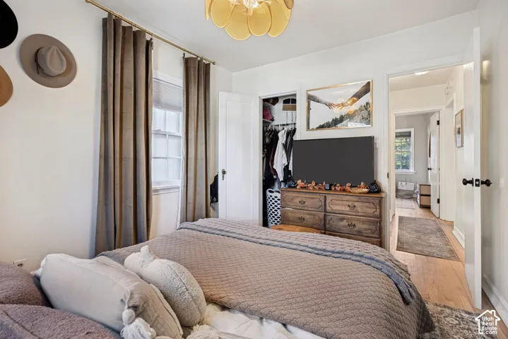 Recessed window featuring a blind, wood-finish flooring, and a ceiling-mounted light fixture