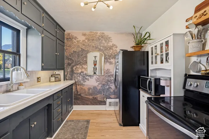 Kitchen featuring dark cabinetry, light countertops, and wood-finish flooring