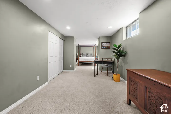 Carpeted flooring throughout, recessed lighting, white trim, and a window providing natural illumination