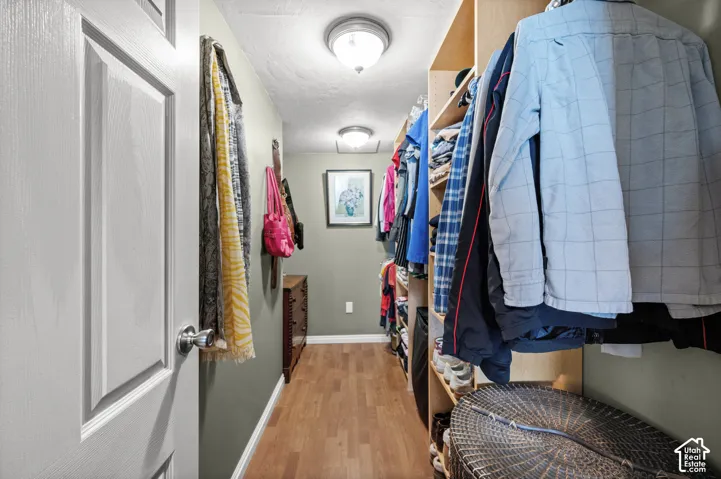 Wood-finish flooring throughout, complemented by built-in wood shelving and recessed lighting