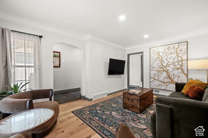 Recessed lighting, wood-finish flooring, and an arched doorway