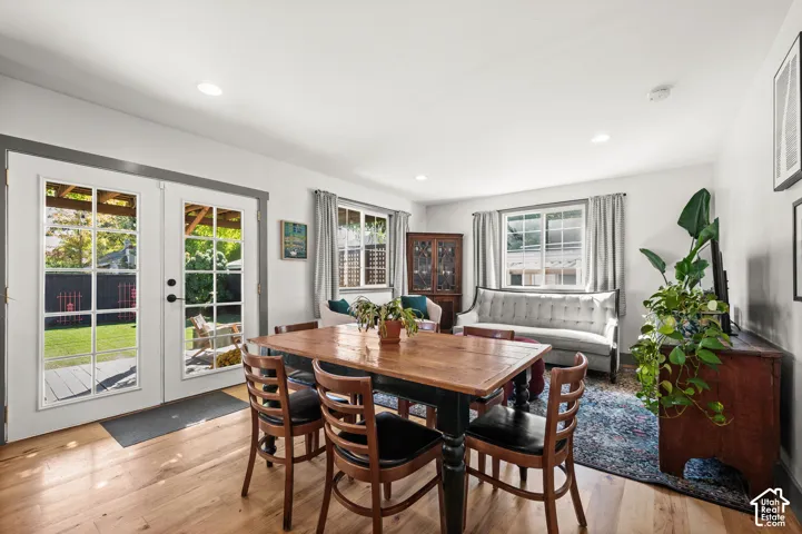 Hardwood flooring, recessed lighting, white walls, and bright white French doors