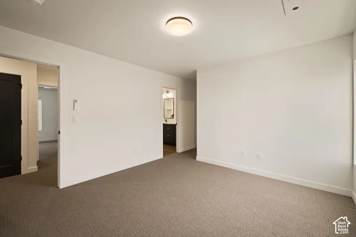 Neutral tone wall paint, flush-mount ceiling light fixture, and textured carpet flooring