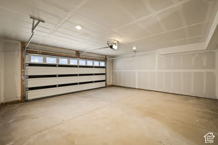 Two-car garage with a sectional overhead door, transom windows, and an automatic opener
