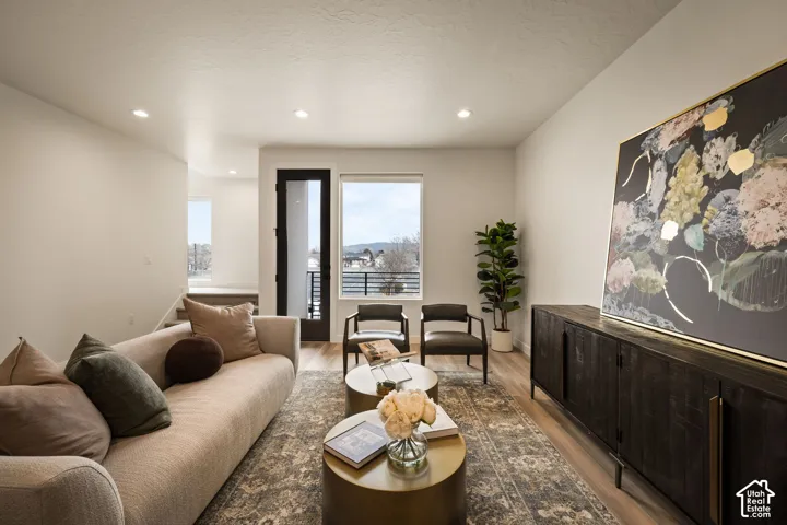 Recessed ceiling lighting, neutral wall paint, wood-finish flooring, and a glass-paneled exterior door
