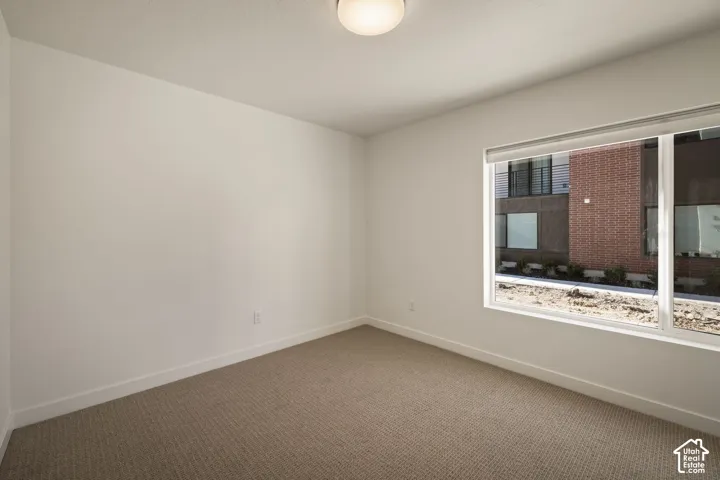 Recessed window with white trim, neutral carpeting, and a flush-mount ceiling light