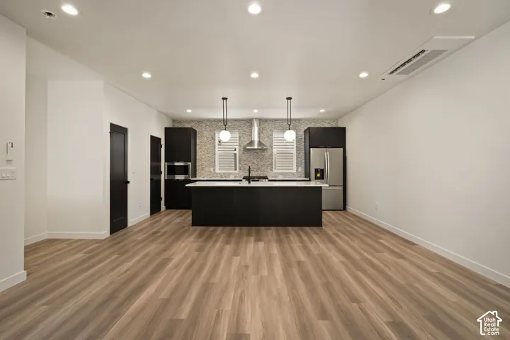 Open-concept living space with wood-finish flooring, recessed lighting, and a modern kitchen