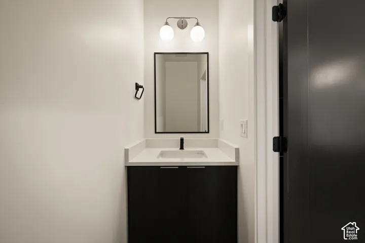 Modern vanity with a rectangular sink, light-toned countertop, and matte black faucet