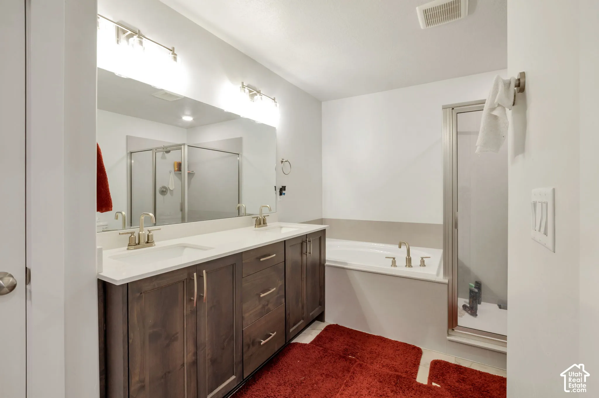 Double vanity with undermount sinks, white countertop, and dark wood-finish cabinetry