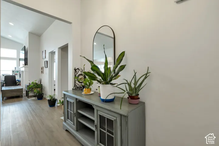 Arched doorway, vaulted ceiling, recessed lighting, wood-finish flooring, white walls