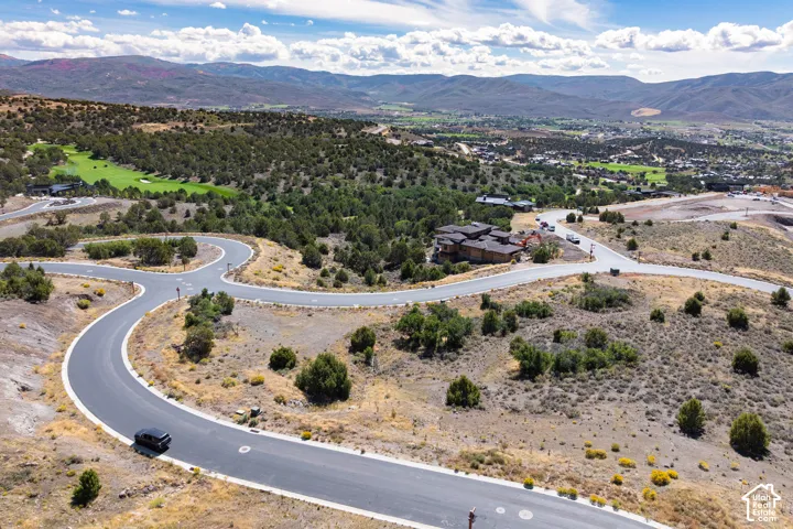 Curving asphalt roads traversing natural desert landscaping with distant mountainous terrain