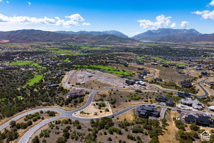 Expansive mountainous landscape with numerous developed properties, paved roads, and green golf course terrain