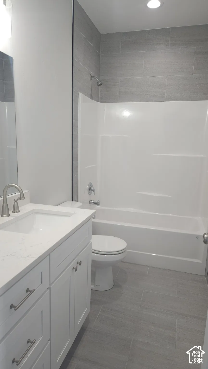Full bathroom featuring a white vanity with an undermount sink, brushed nickel faucet, and a light-toned countertop