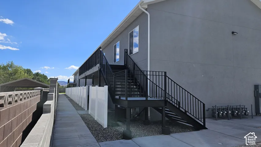 Exterior staircase with black metal railings, leading to upper-level entrances