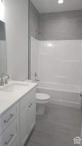 Full bathroom featuring a white vanity with an undermount sink, brushed nickel faucet, and a light-toned countertop
