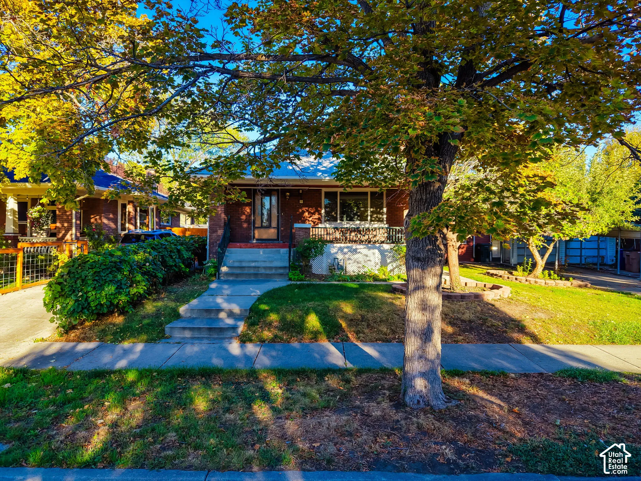 Brick exterior with a covered porch featuring metal railings