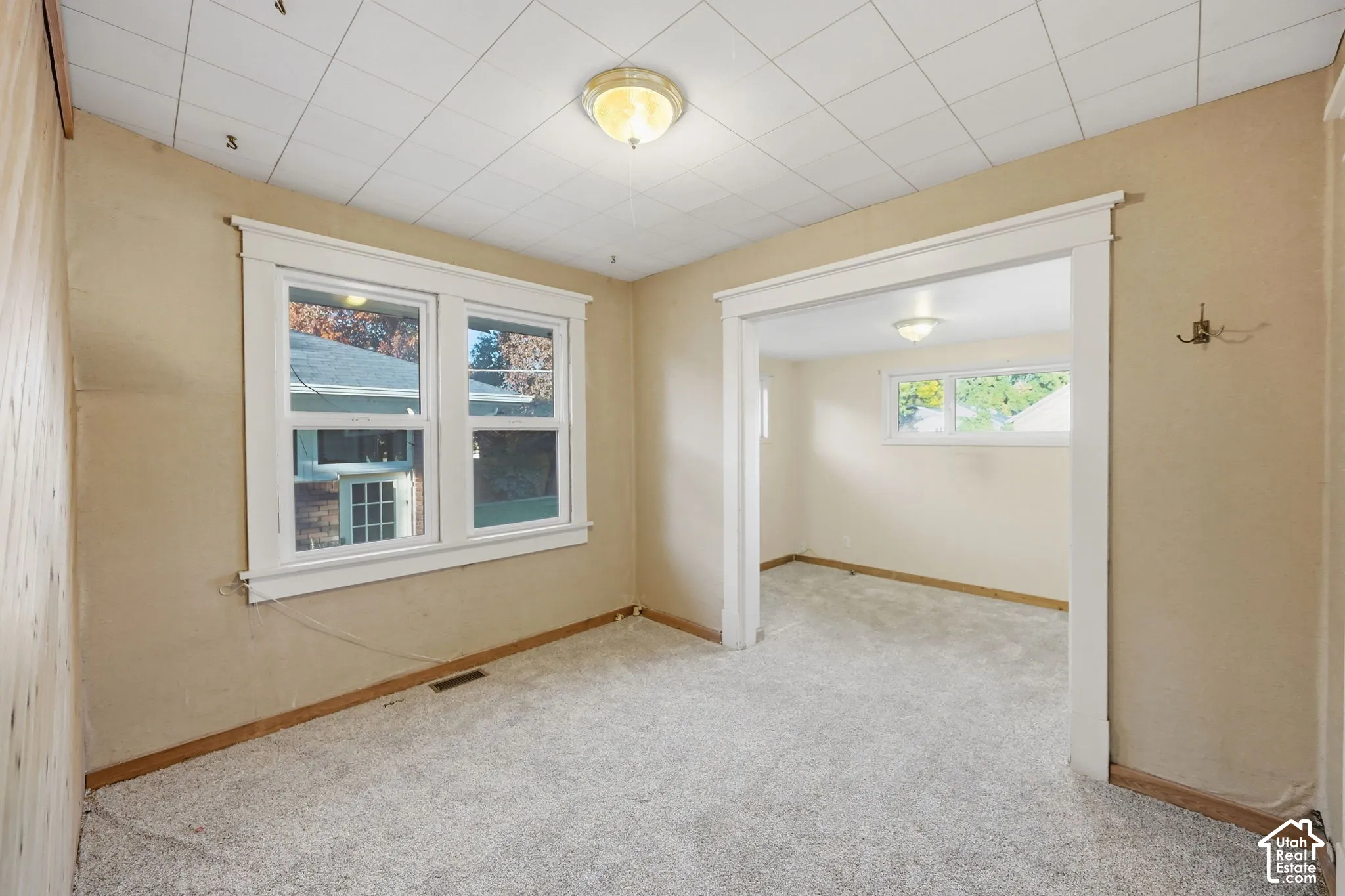 Carpeted room with a wide doorway and a double window