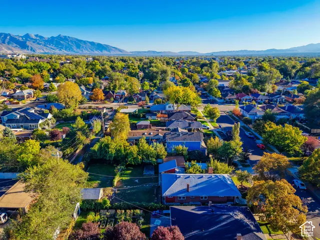 Expansive residential area with mature trees, visible mountain range, and clear sky
