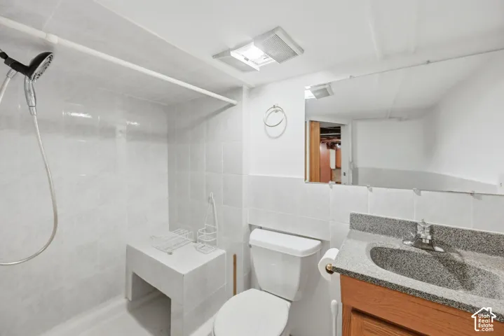Tiled shower stall with an integrated bench and handheld shower head
